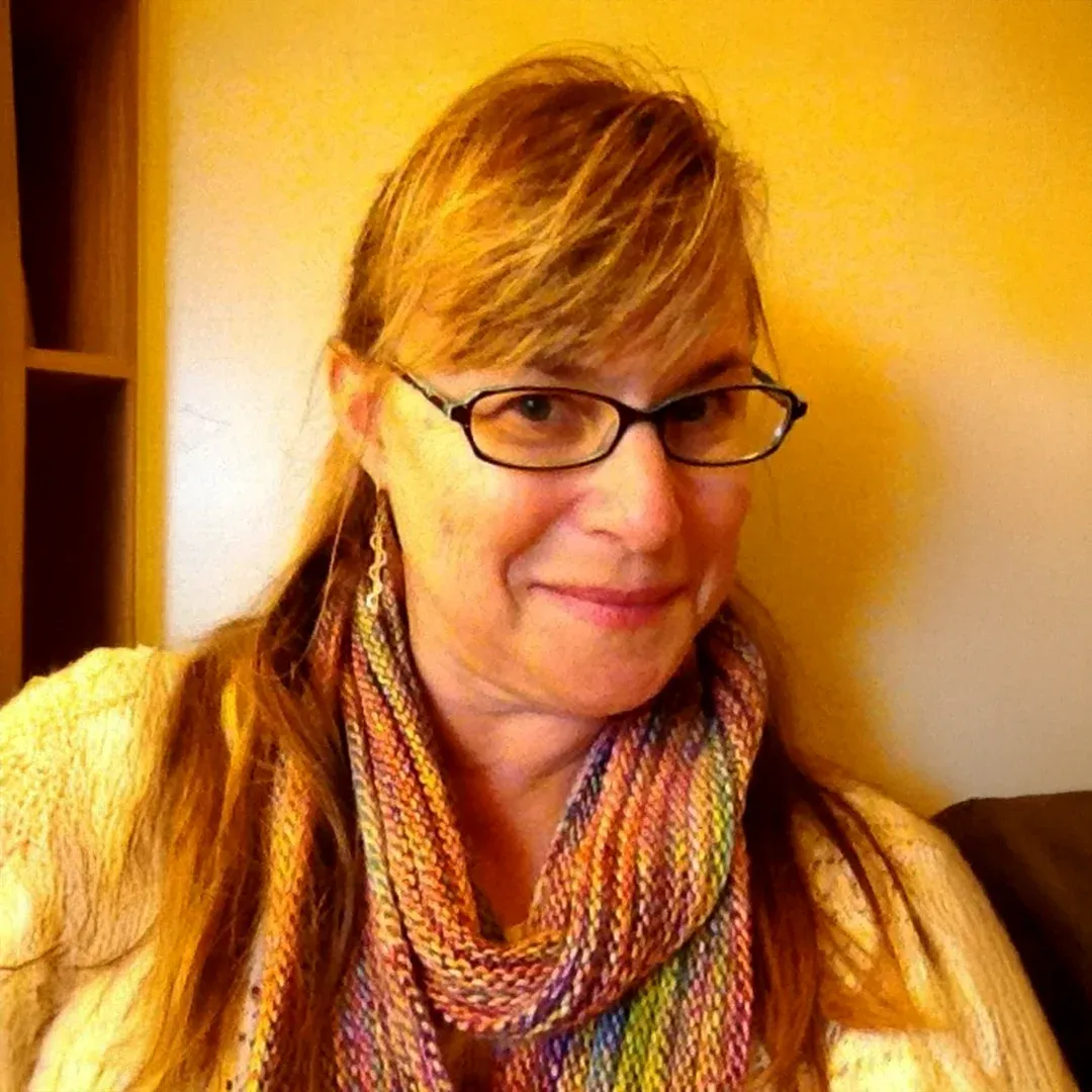 Portrait Of Daniella Zimmerman Wearing Glasses And A Colorful Scarf Daniella Zimmerman wearing glasses and a colorful scarf while smiling indoors